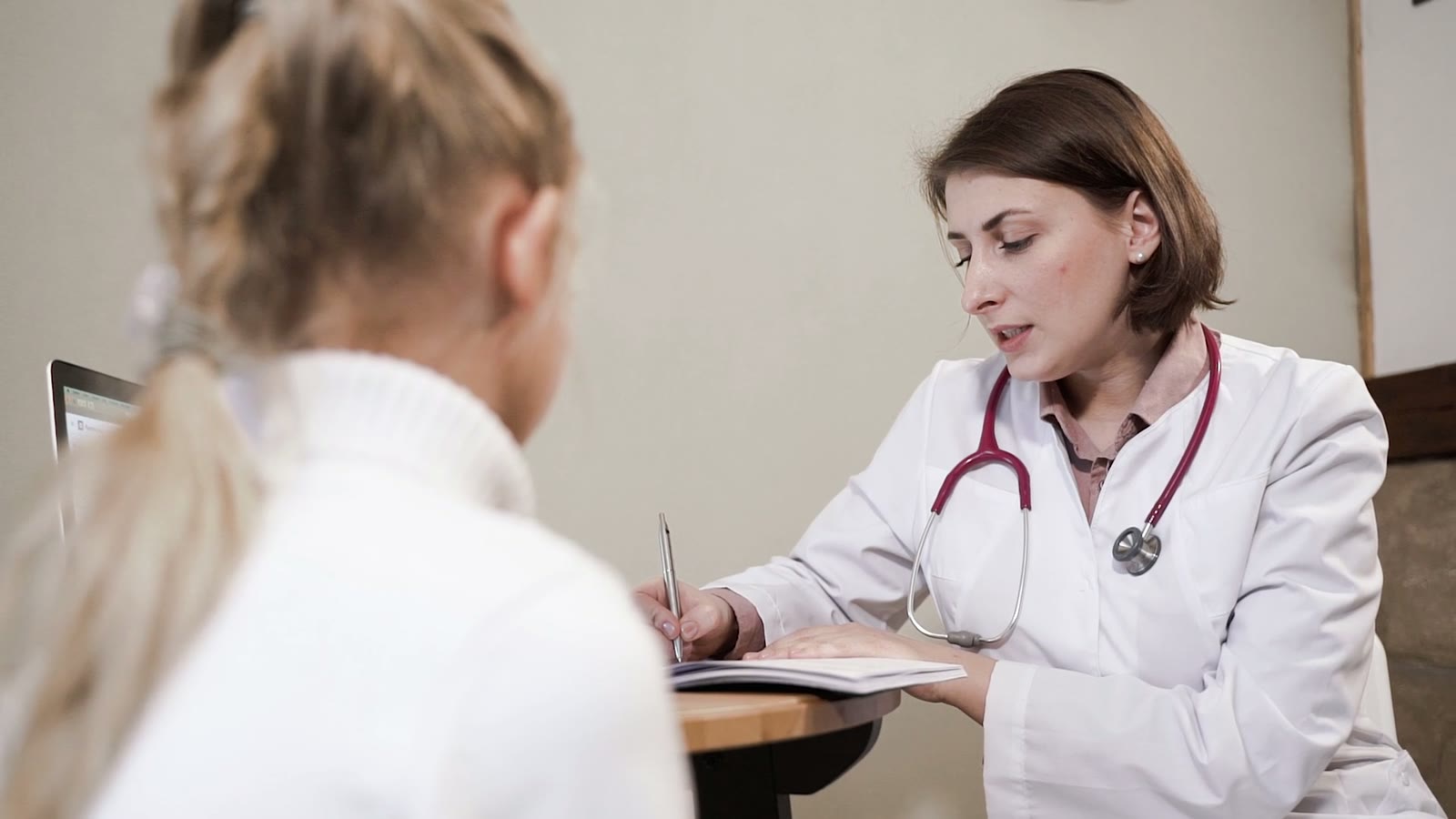 Une médecin prend des notes pendant un entretien